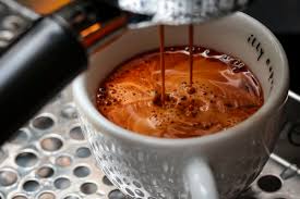 A close-up photo of a Like Watery Coffee NYT steaming cup of coffee on a saucer, with wisps of steam rising from the surface 2